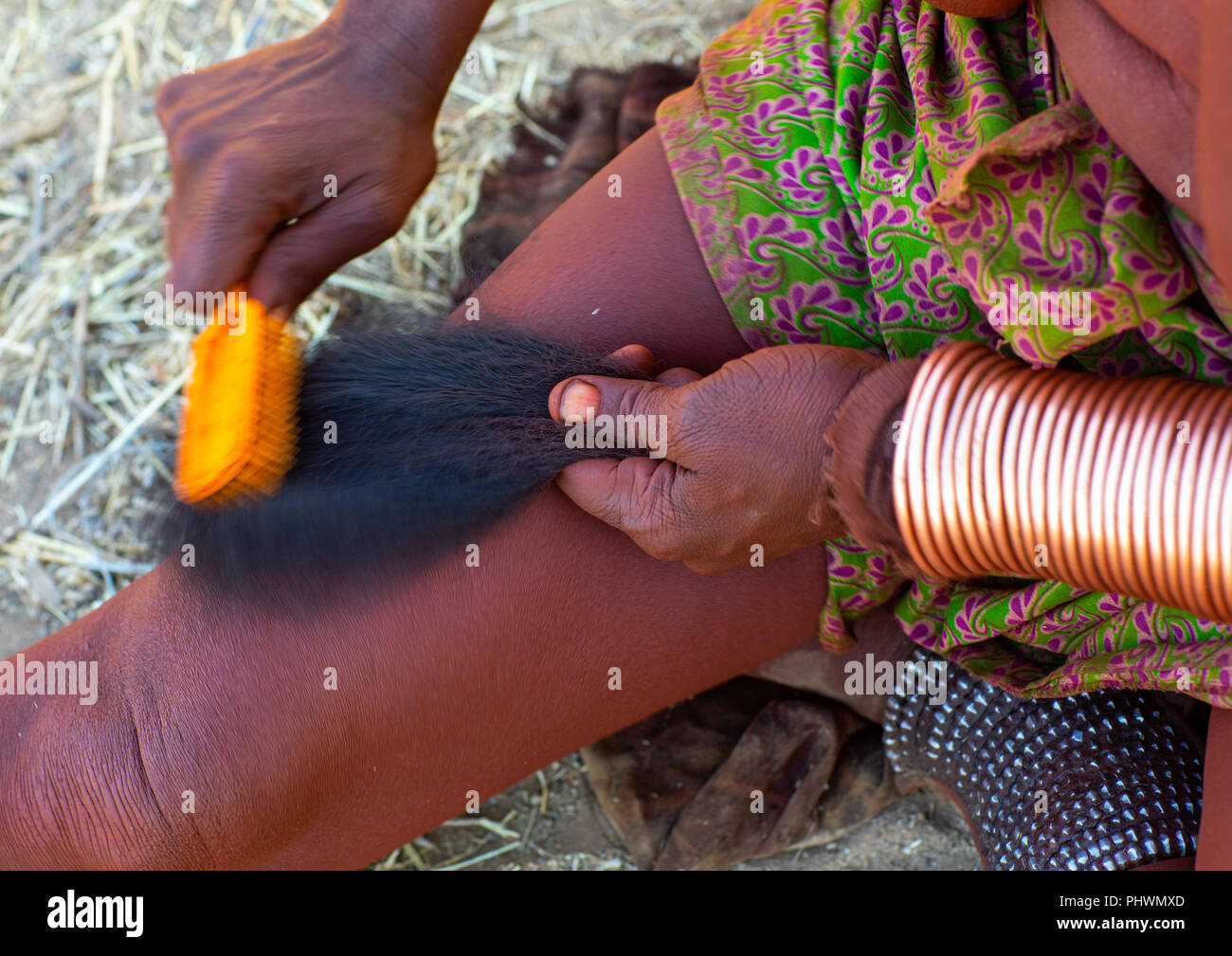 Himba Frau dreadlocks Kämmen mit Haarverlängerungen, Cunene Provinz, Oncocua, Angola Stockfoto