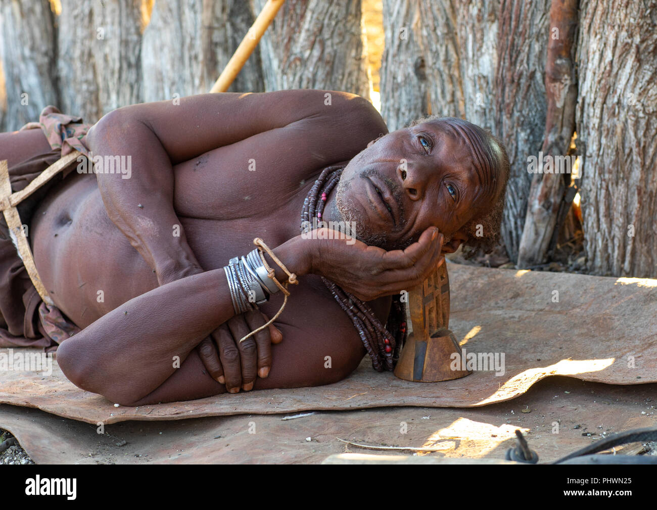 Himba alter Mann rast mit seinem Holz- Kissen, Cunene Provinz, Oncocua, Angola Stockfoto