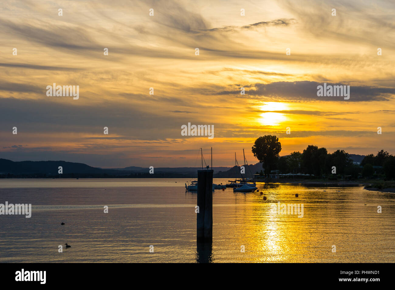 Orange gemalten Himmel und Boote auf stillen Wasser des Sees in der Morgendämmerung Stockfoto