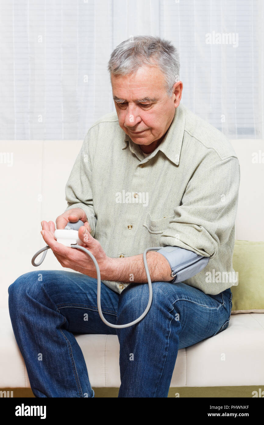 Alterer Mann Sitzt Auf Einem Sofa Zu Hause Und Blutdruck Messen