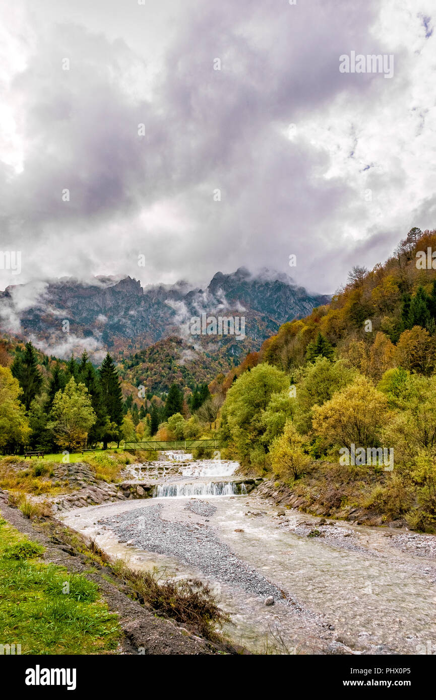 Herbst Landschaft in den Alpen von einem Bach und Wasserfall zwischen Natur und Berge an einem bewölkten Tag, Bergamo, Bergamasker, Tal brembana Lokalität Cassigl Stockfoto