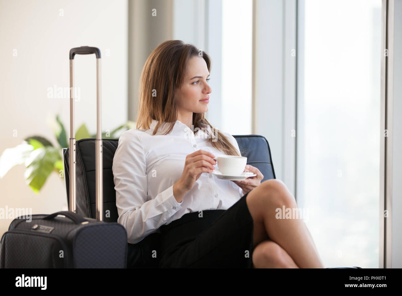 Nachdenklich Geschäftsfrau Kaffee trinken mit Gepäck im Flughafen Stockfoto