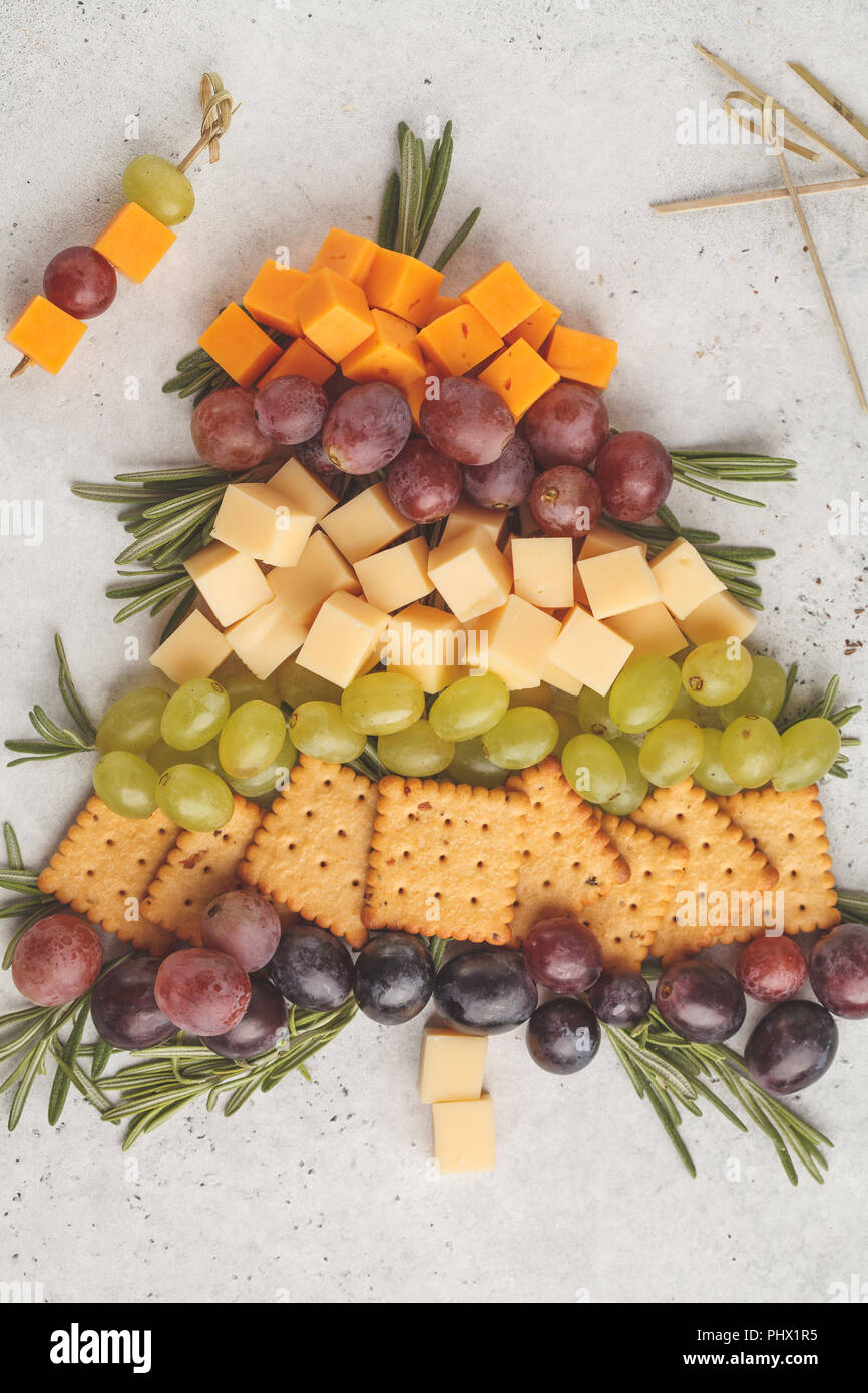 Weihnachtsbaum aus Vorspeisen: Käse, Trauben, Cracker. Weihnachten Lebensmittel Konzept, weißen Hintergrund. Stockfoto