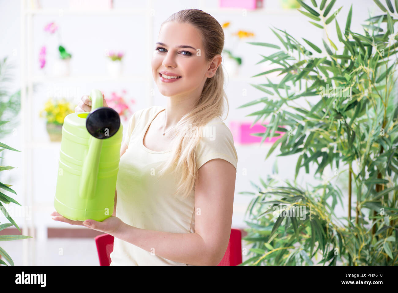 Junge Frau, Bewässerung von Pflanzen in Ihrem Garten Stockfoto