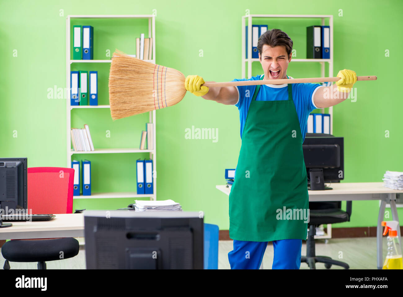 Junge männliche gutaussehenden professionelle Reiniger Reinigung Boden mit Br Stockfoto