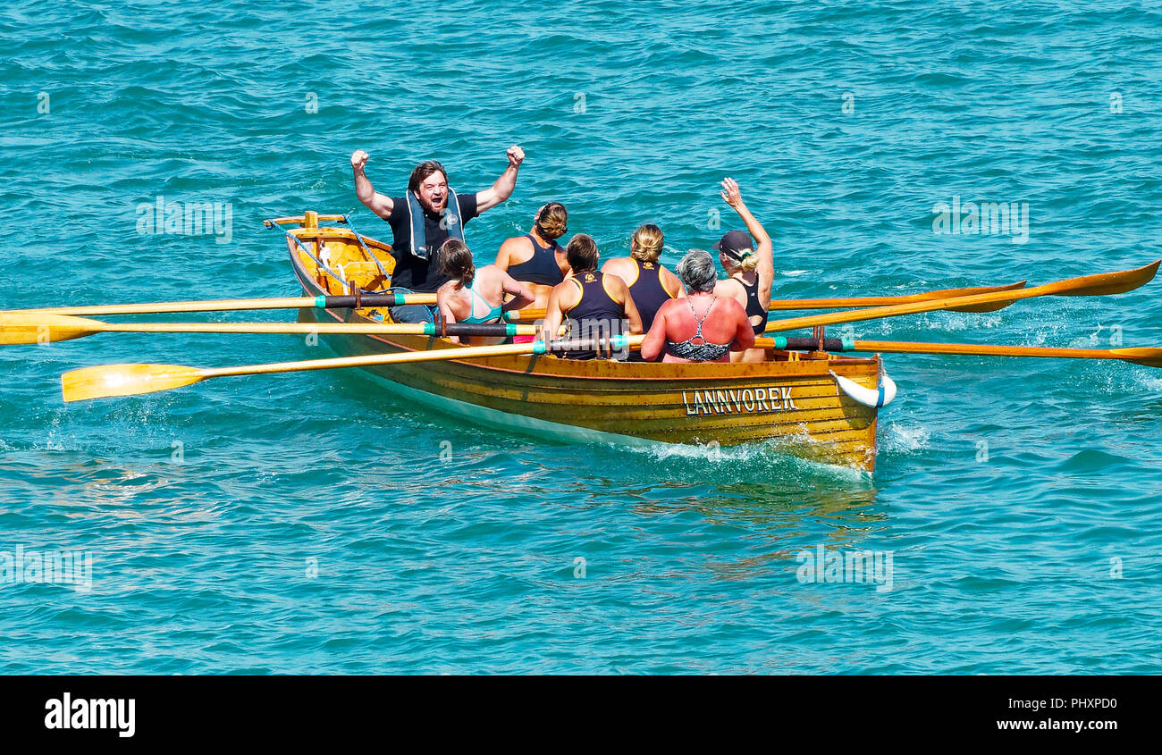 Newquay, Großbritannien. 3. September 2018. Traditionelle Pilot gig Rennen. Cornwall Damen Meisterschaft 2018, l Mounts Bay weiblichen Penzance C Crew macht durch den ausgezeichneten als Gesamtsieger im Wettbewerb. Jubilant cox Graham Nicholas begrüßt seine Veteranen klasse weibliche Mannschaft 03, September, 2018 Robert Taylor/Alamy leben Nachrichten Newquay, Cornwall, England. Credit: Robert Taylor/Alamy leben Nachrichten Stockfoto