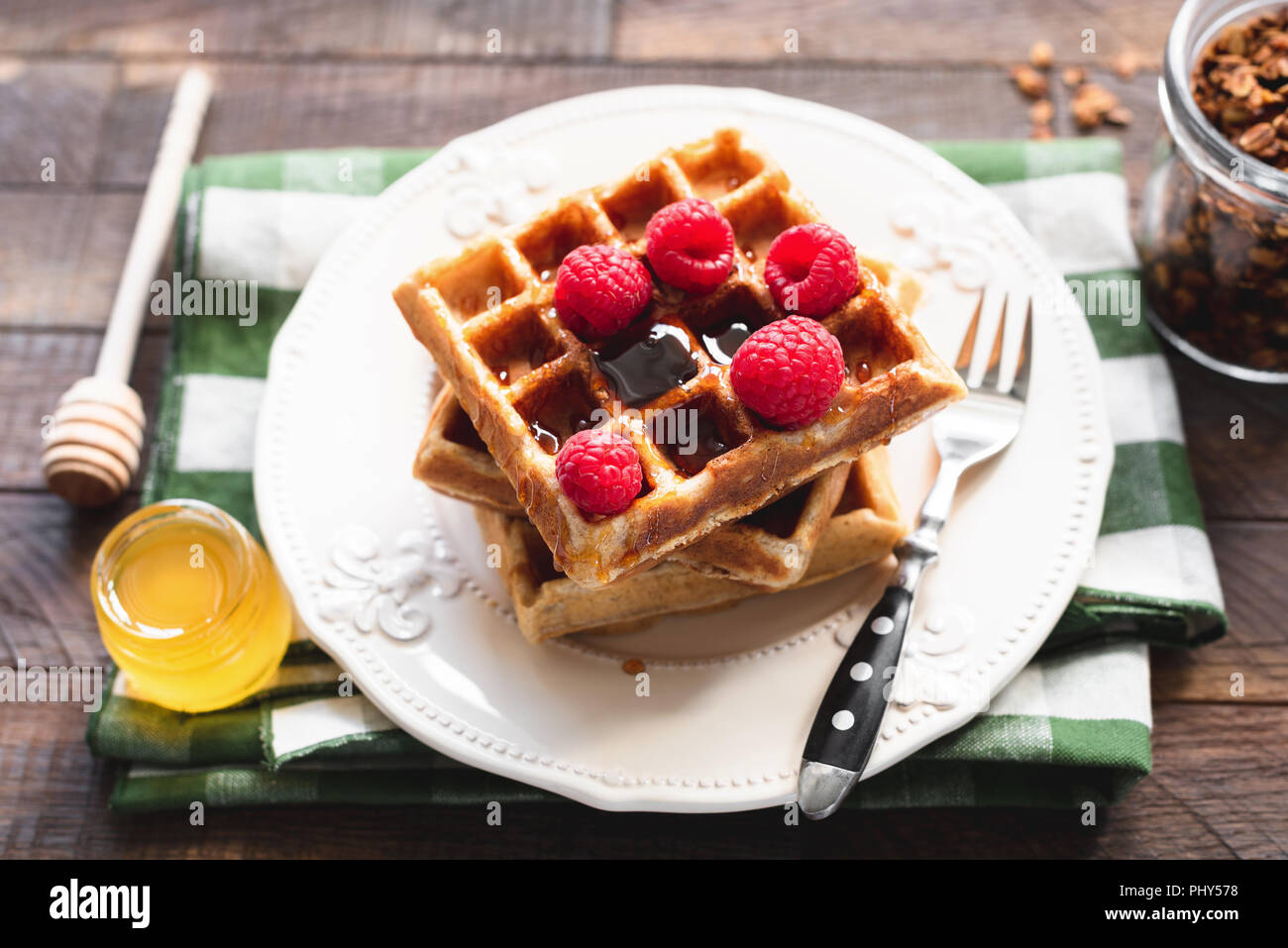 Belgische Waffeln mit Himbeeren und Honig. Platz mit hausgemachten belgischen Waffeln. Leckeres Frühstück. Stockfoto