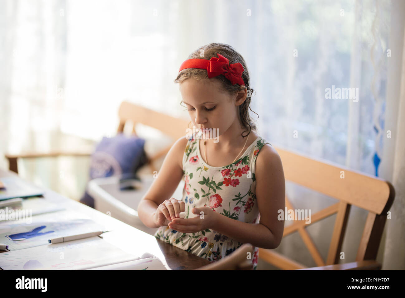 Eine charmante siebenjähriges Mädchen schafft Begeisterung Papier basteln. Hobbys und Interessen. Stockfoto