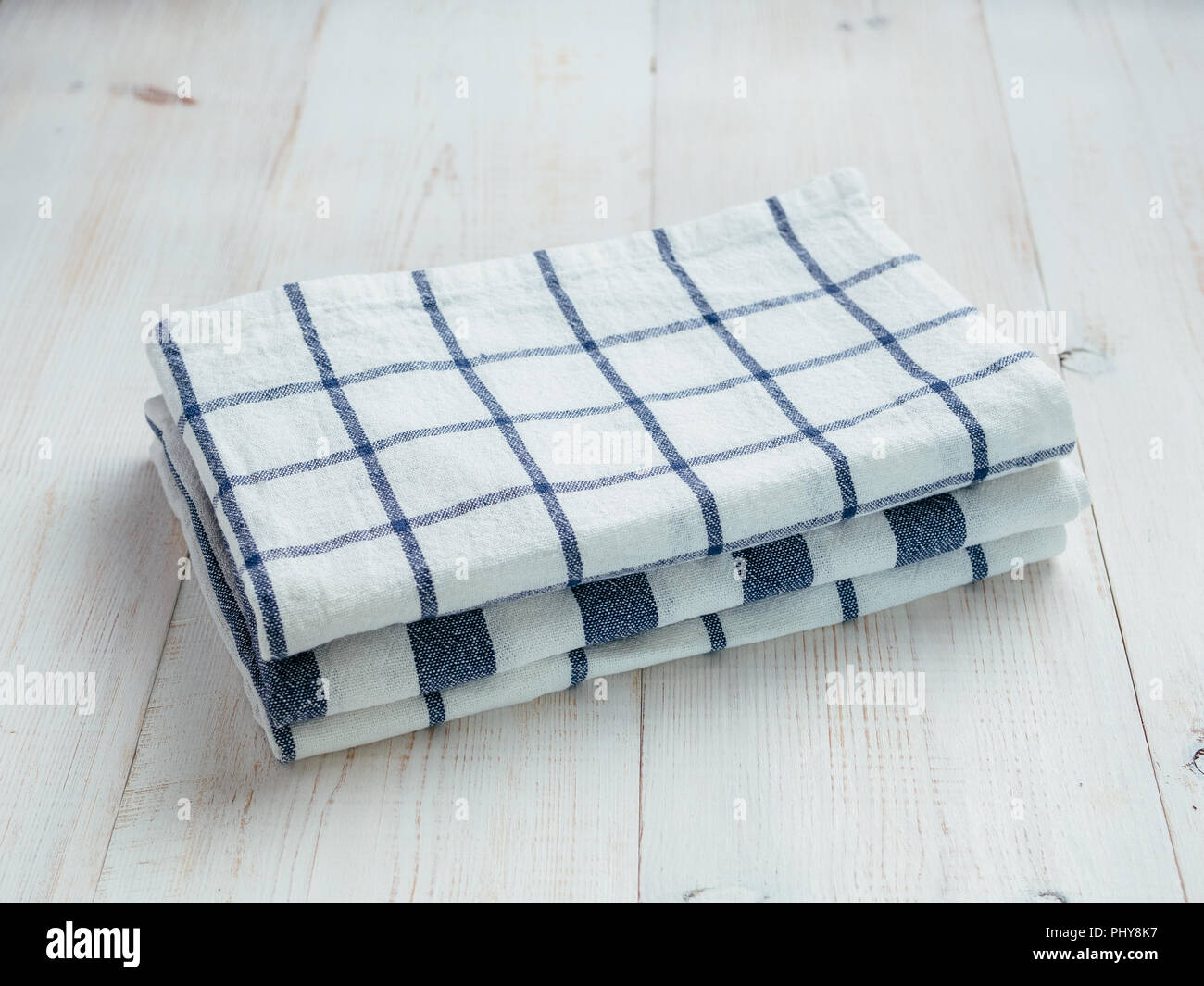 Stapel von Weißen und Blauen Geschirrtücher Handtücher. Stapel von drei farbige Geschirrtücher auf weissem Holztisch. Kopieren Sie Platz für Text. Stockfoto