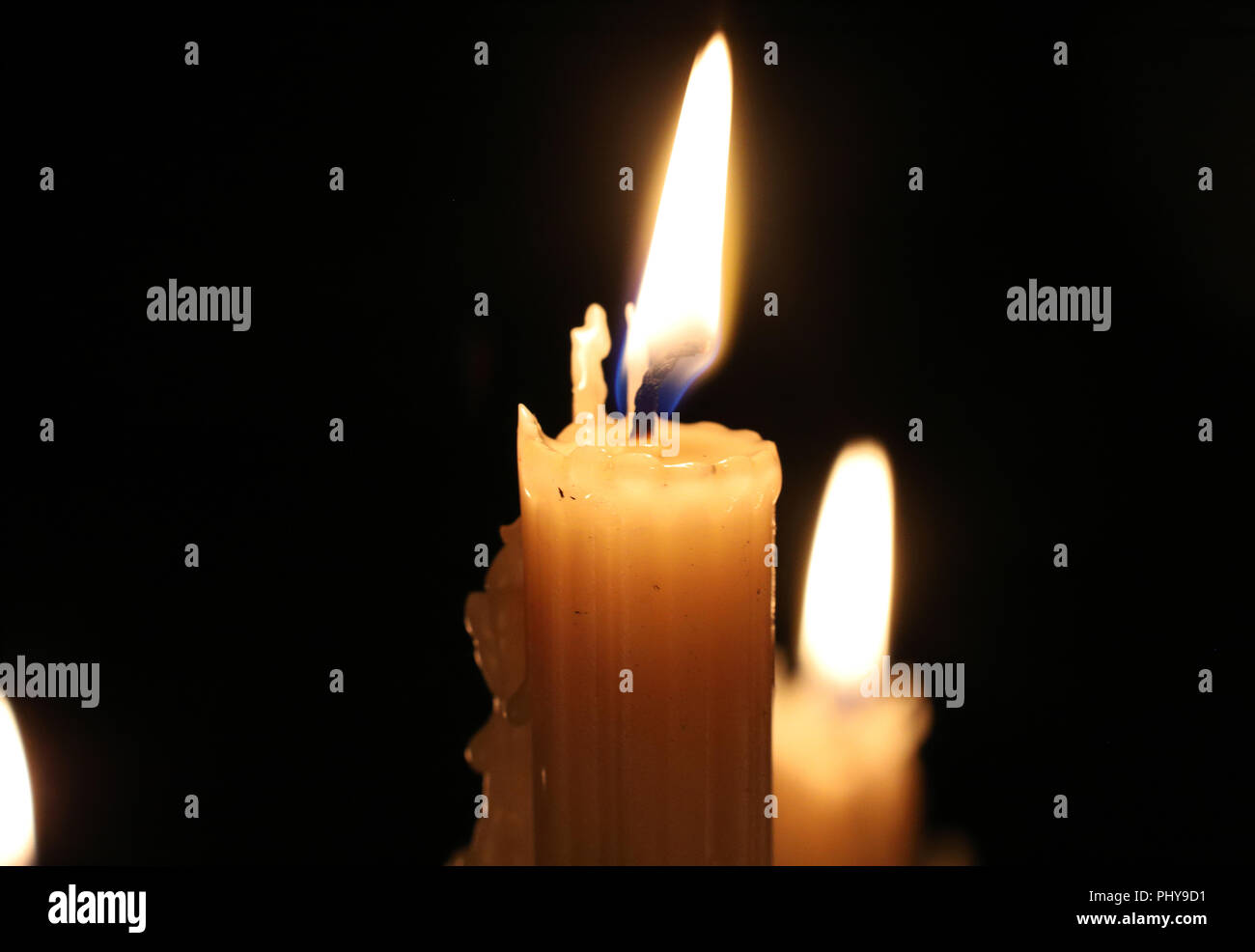 In der Nähe von brennenden Kerzen in der Dunkelheit. Kerze Flamme, Docht.  Weihnachten, Neujahr, Grußkarte, Allerheiligen, All Hallows Eve, Kirche,  Religion, Glaube, Gebet, Urlaub, magisch Stockfotografie - Alamy