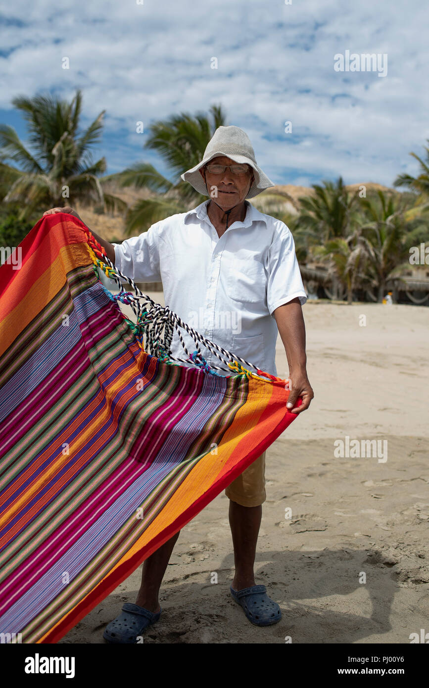 Unbekannter lokaler Mann mit Gewebe und Hängematten für den Verkauf auf dem Strand von Las Pocitas, in der Nähe von Mancora, Peru. Nur für den redaktionellen Gebrauch bestimmt. Aug 2018 Stockfoto