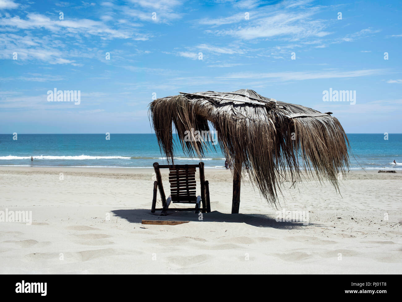Rustikal Strandkorb und Stroh Regenschirm mit türkisblauem Meer. Entspannte Stimmung auf Vichayito Beach in der Nähe von Mancora, Region Piura, Peru. Aug 2018 Stockfoto