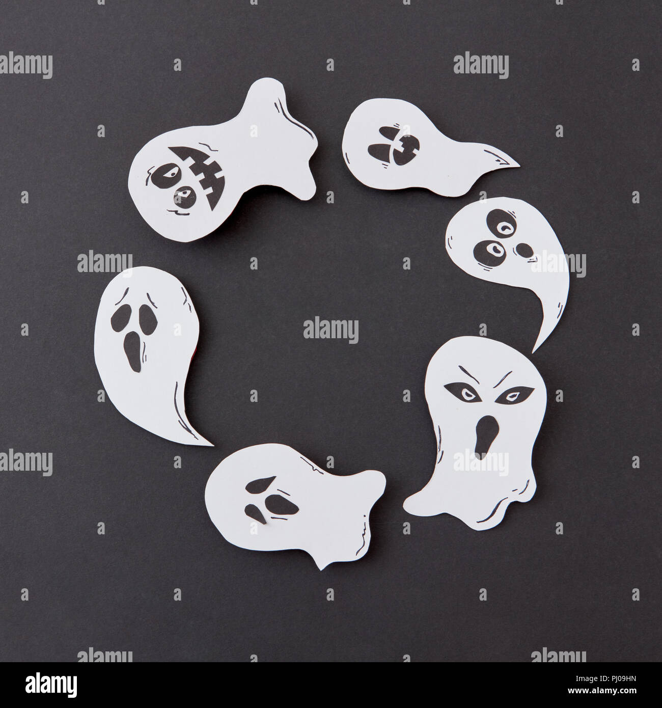 Happy Halloween. Handwerk runden Rahmen von Flying floating Singen lächeln Gespenster auf schwarzem Hintergrund. Stockfoto