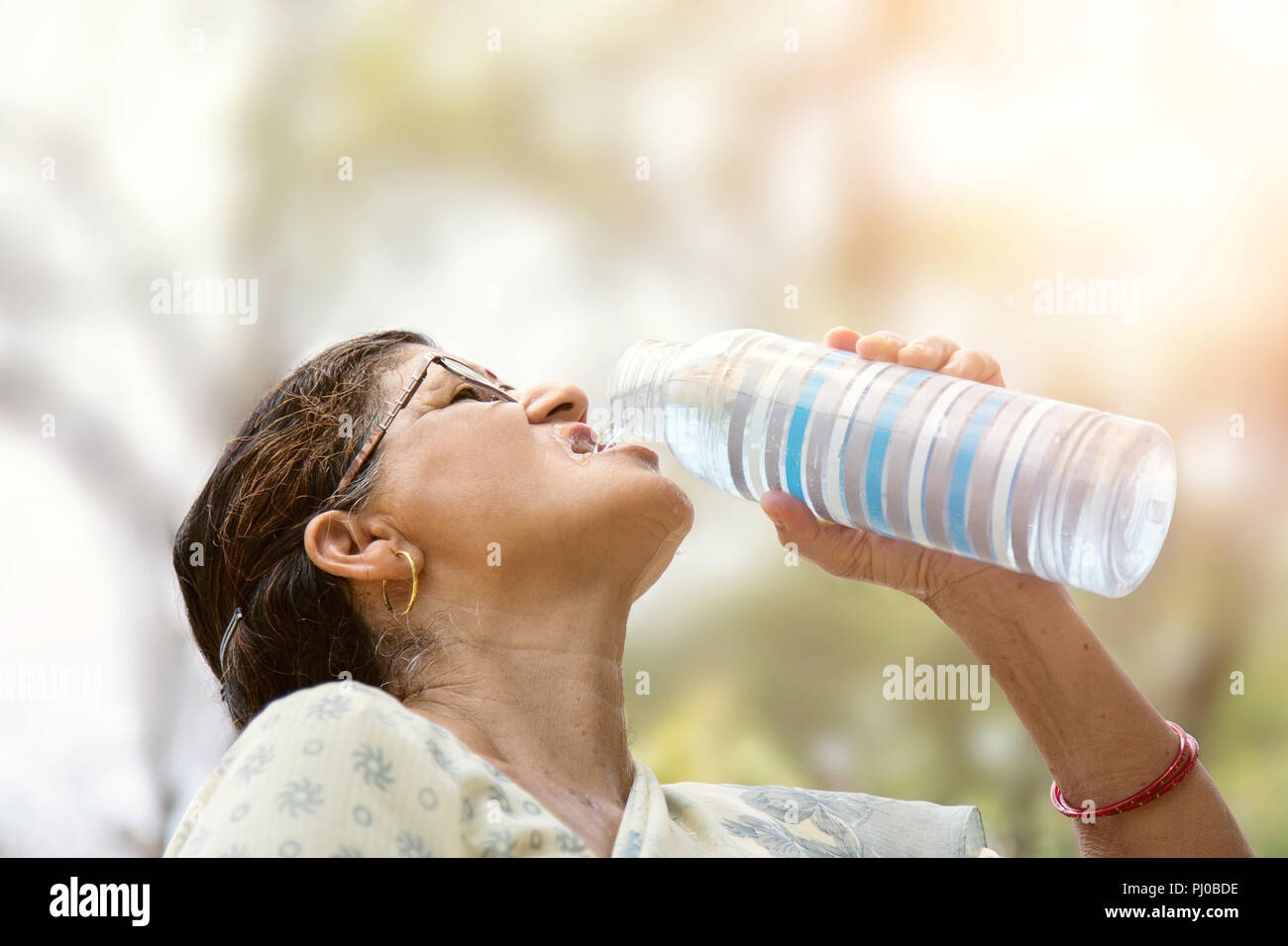 Indische Frau Trinkwasser aus der Flasche Stockfoto