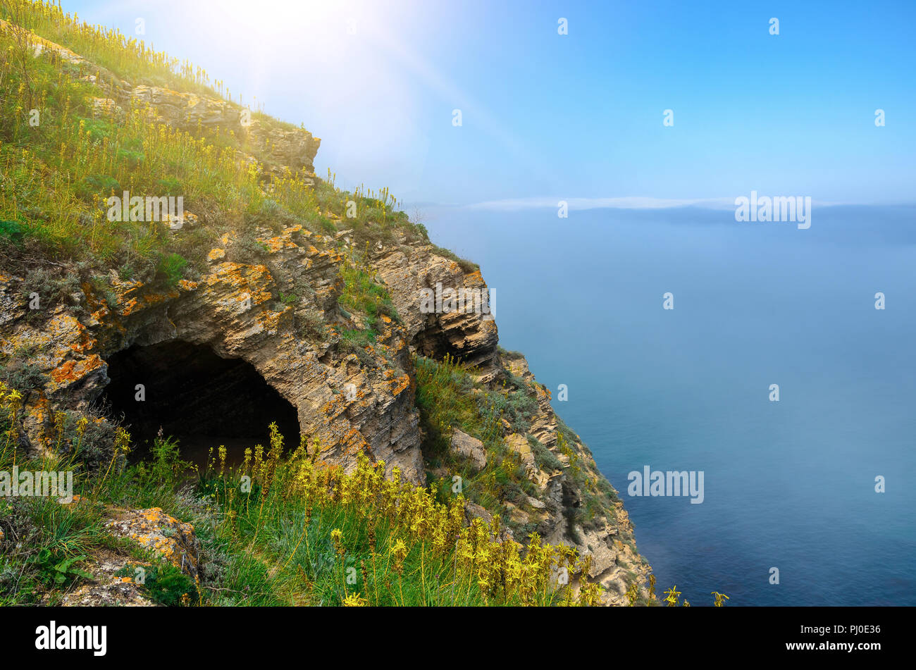 Höhle in einem Felsen am Meer. Über dem Wasser sehen sie den Nebel. Stockfoto