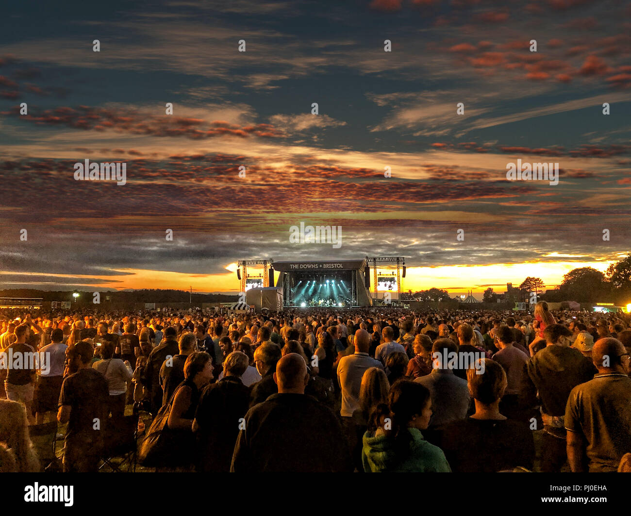 Große Masse gerade Musik auf einer Bühne bei Sonnenuntergang auf einem Festival in Bristol (Abschreibungen) Sommer vibes. Stockfoto