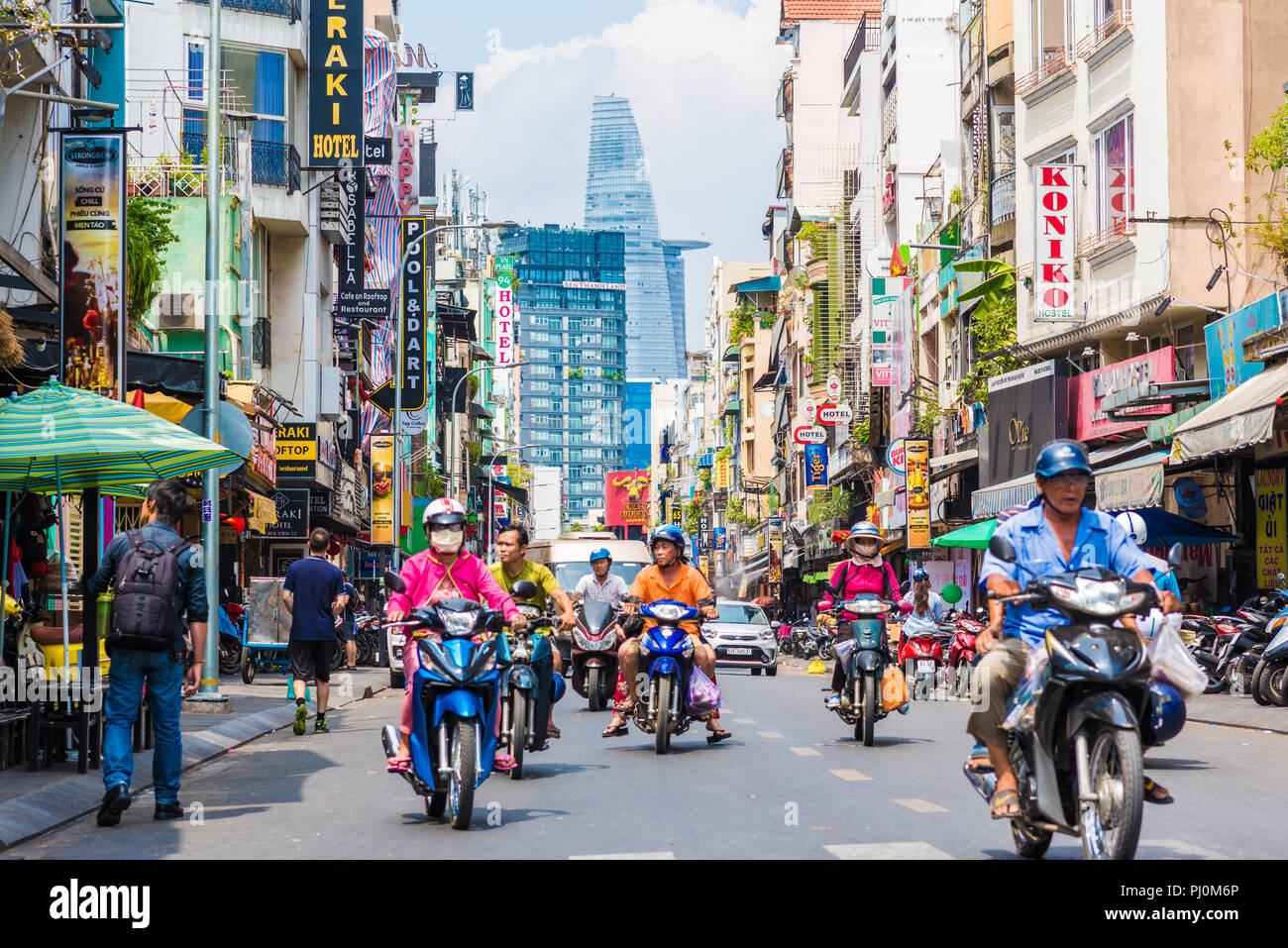 Ho Chi Minh City, Vietnam - die Bui Vien Street Perspektive, zahlreiche Firmenschilder, Menschen, Motorräder, bitexco Tower. Stockfoto