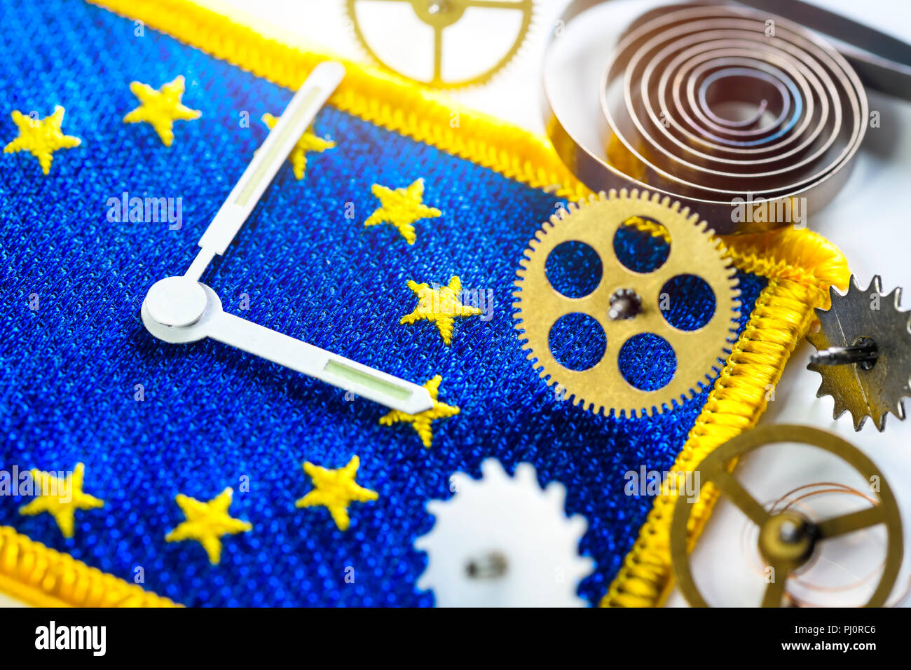Sehen Sie sich die Hände und Zahnräder auf EU-Flagge, Ende der ändern Uhren in der EU Stockfoto