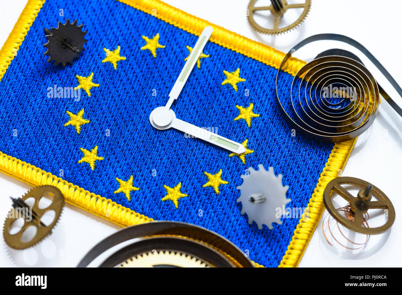 Sehen Sie sich die Hände und Zahnräder auf EU-Flagge, Ende der ändern Uhren in der EU Stockfoto