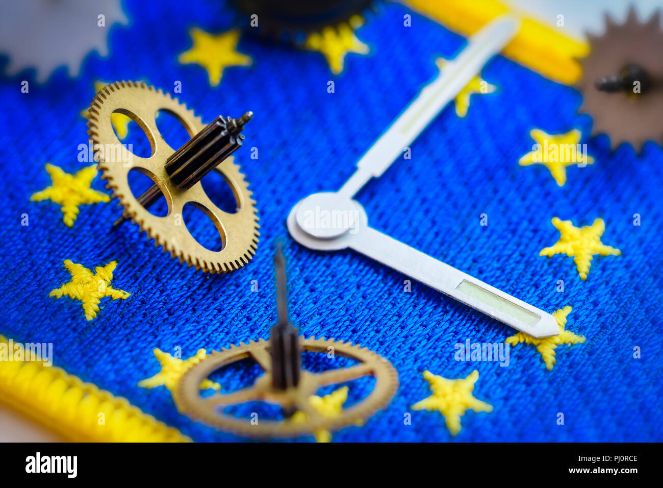 Sehen Sie sich die Hände und Zahnräder auf EU-Flagge, Ende der ändern Uhren in der EU Stockfoto