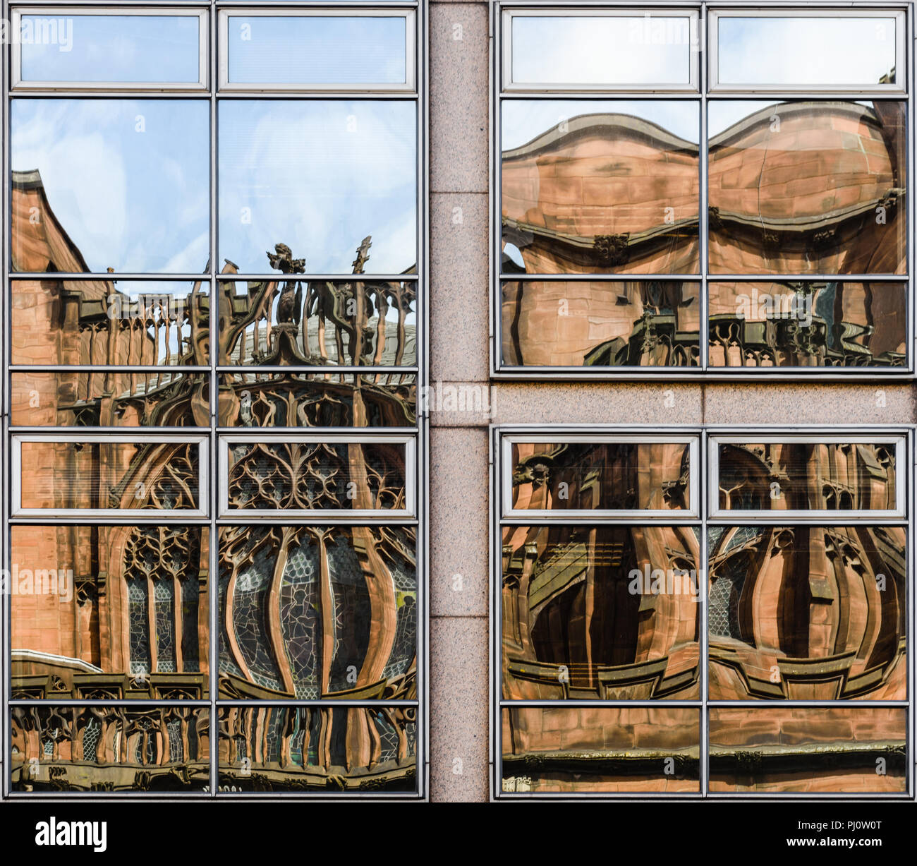 Verzogene Reflexionen von John RYLAND's Library in den Fenstern von einem gegenüberliegenden Gebäude auf Deansgate, Manchester Stockfoto