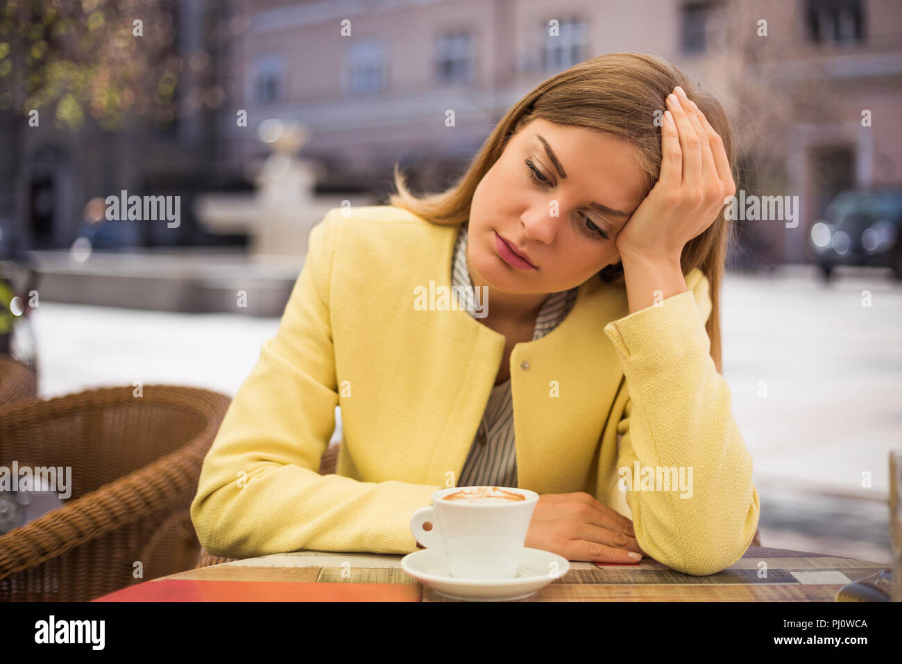 Schöne traurige Frau allein im Cafe sitzen. Stockfoto