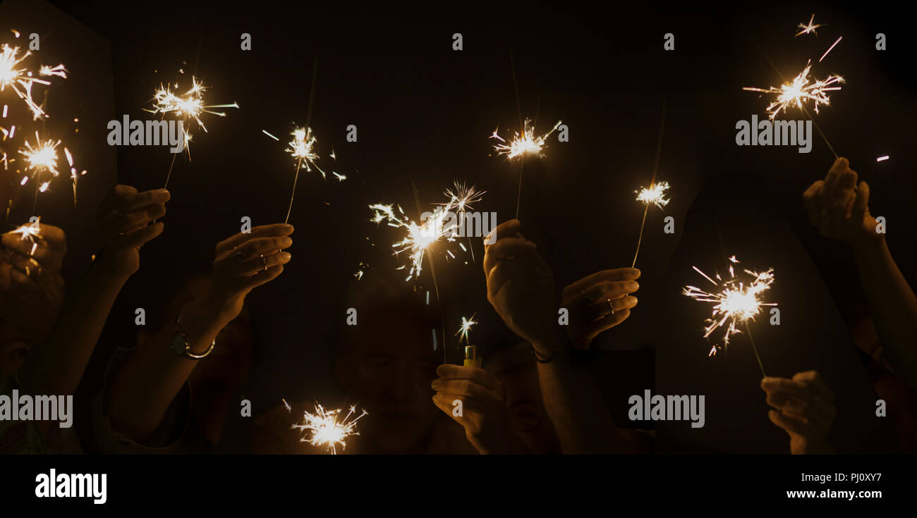 Dunkle Nacht feiern Konzept mit Menge Hände zu nehmen und die Verwendung von Hell funkelt Feuer zusammen. Spaß für Silvester oder Partei haben. Begleitung und fr Stockfoto