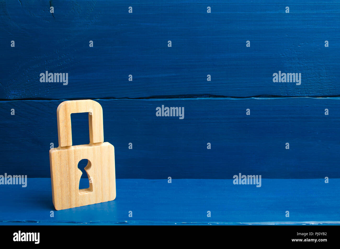 Eine hölzerne Schloss auf einem blauen Hintergrund, Informationen, Eingang. Konzept der Bewahrung von Geheimnissen, Informationen und Werte. Schutz der Daten und der p Stockfoto