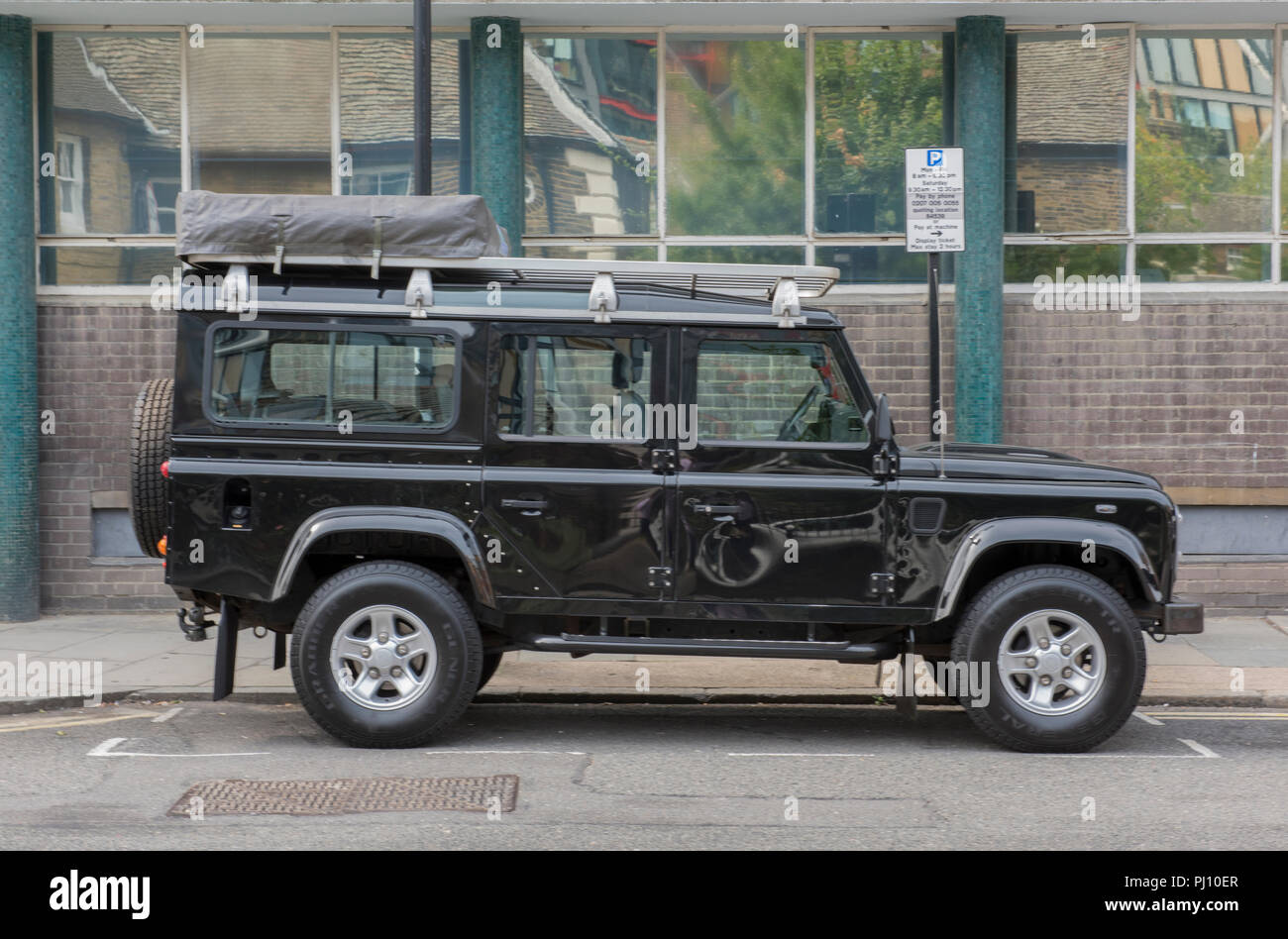 Ein Land Rover Defender 110 county Station Wagon Allrad Off-Road-Fahrzeug mit einer Expedition Dachgepäckträger. Stockfoto