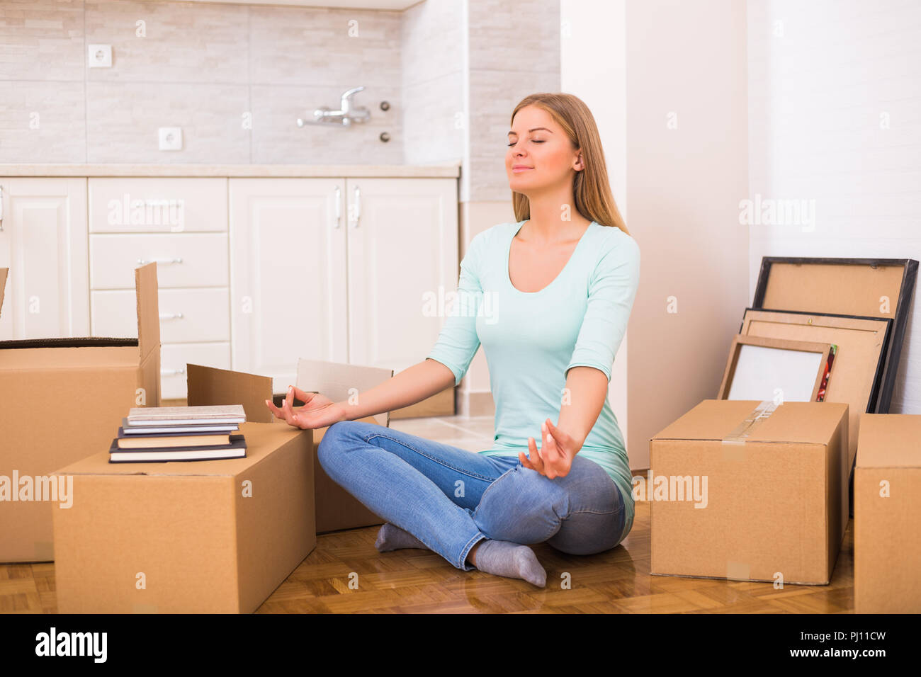Schöne Frau Ruhe und Meditation beim Einzug in Ihre neue Wohnung. Stockfoto