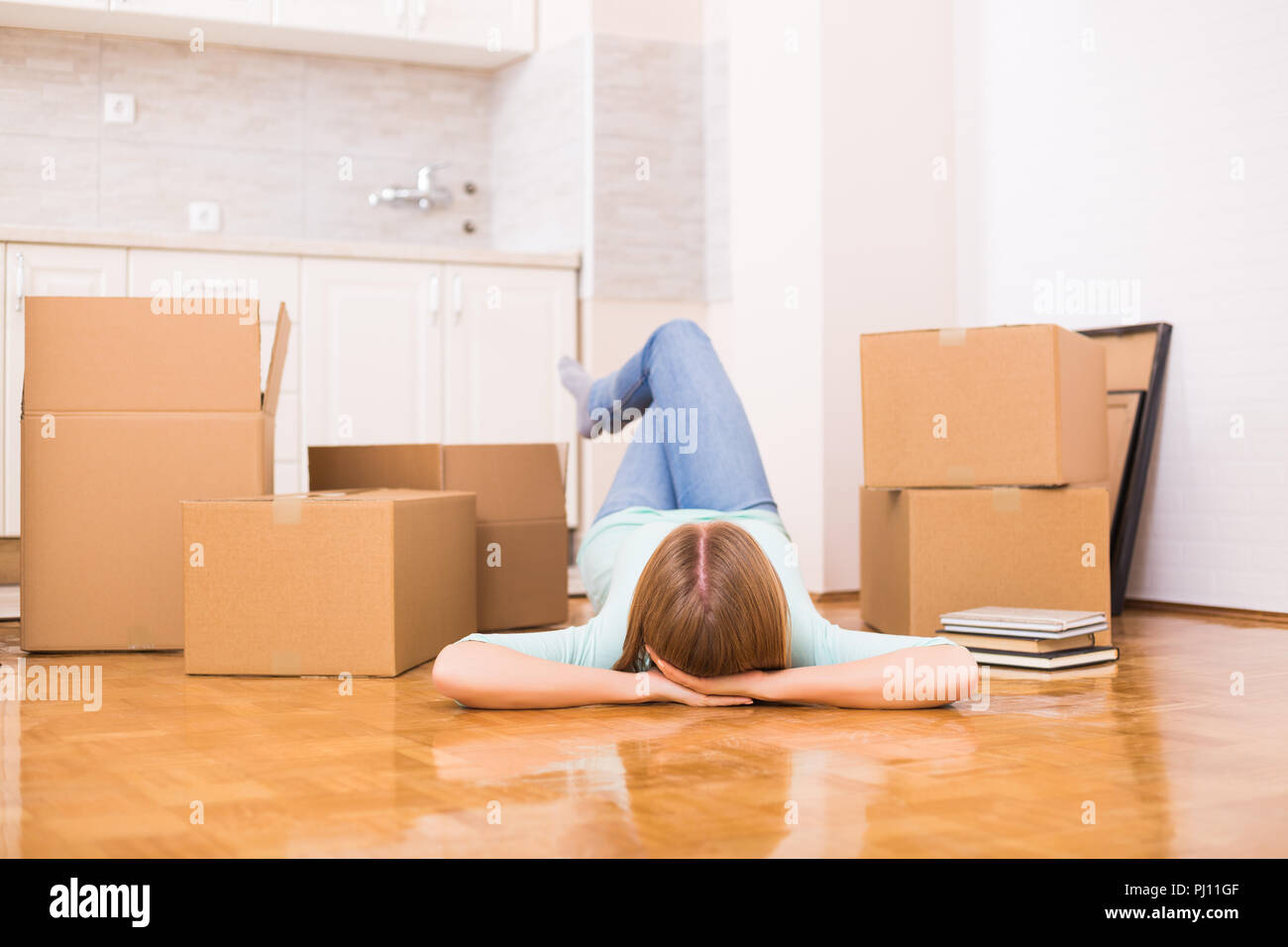 Frau genießt auf dem Boden in Ihrem neuen Zuhause. Stockfoto