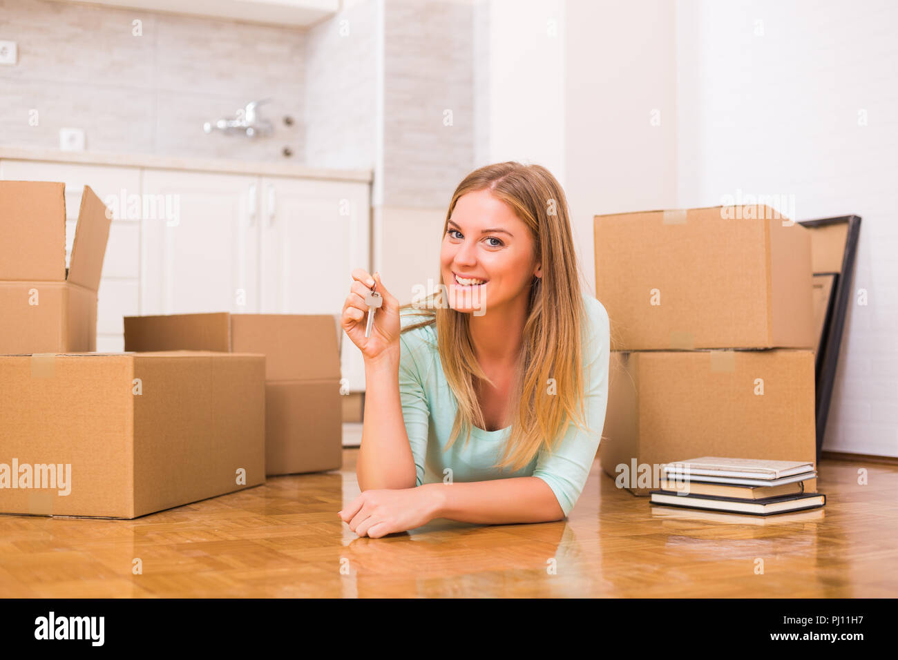 Schöne Frau mit Schlüssel zu Ihrem neuen Zuhause. Stockfoto