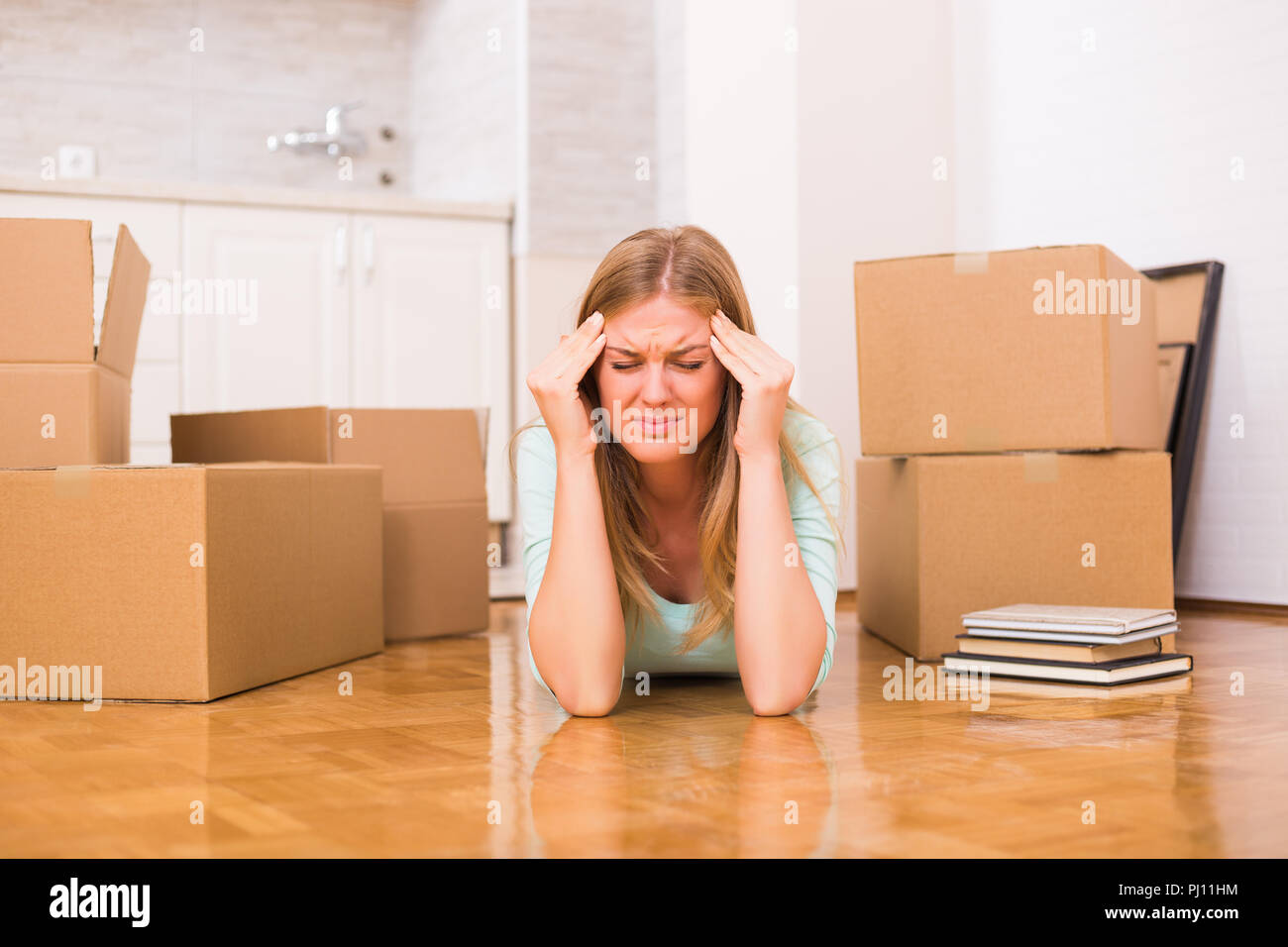 Frau mit Kopfschmerzen, weil der Umzug in die neue Heimat. Stockfoto