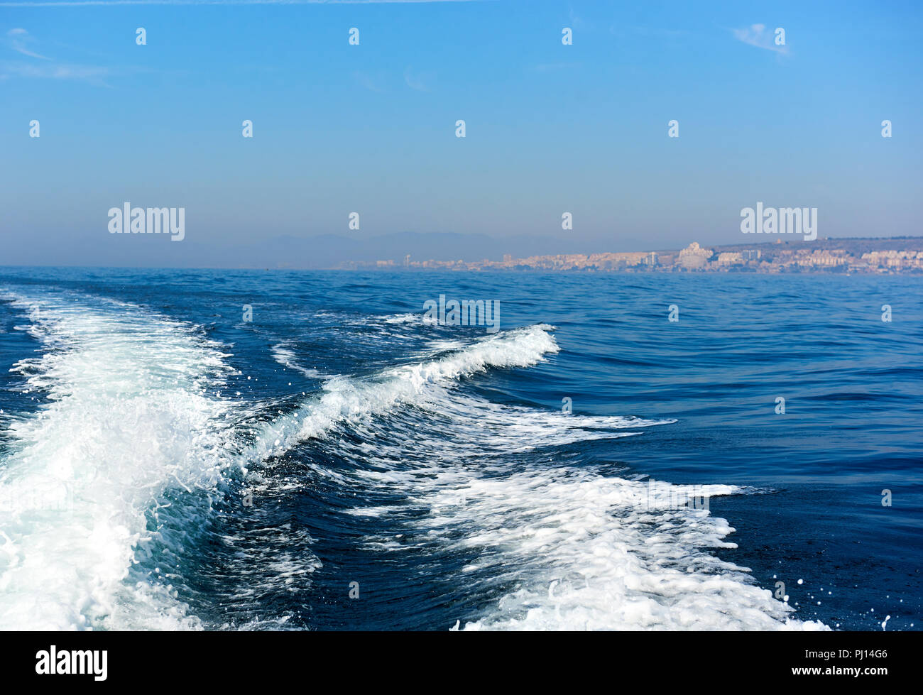 Wellenförmige trail auf das Mittelmeer nach Schiff, Schiff, Fähre Geschwindigkeit schwebend. Touristische Fähre im Mittelmeer von Santa Pola Spanien schwimmen Stockfoto