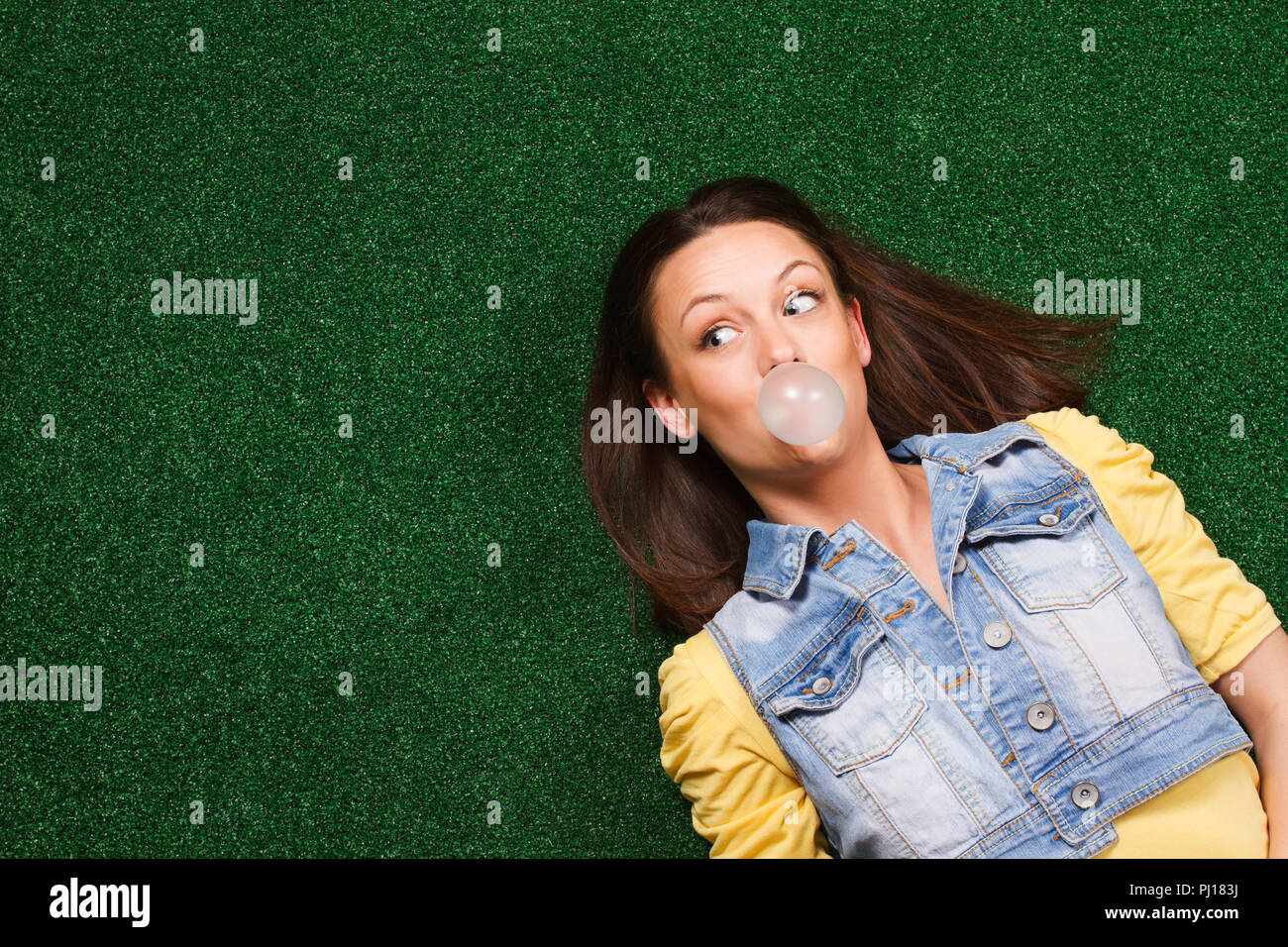 Frau blasen Bubble Gum und Denken Stockfoto