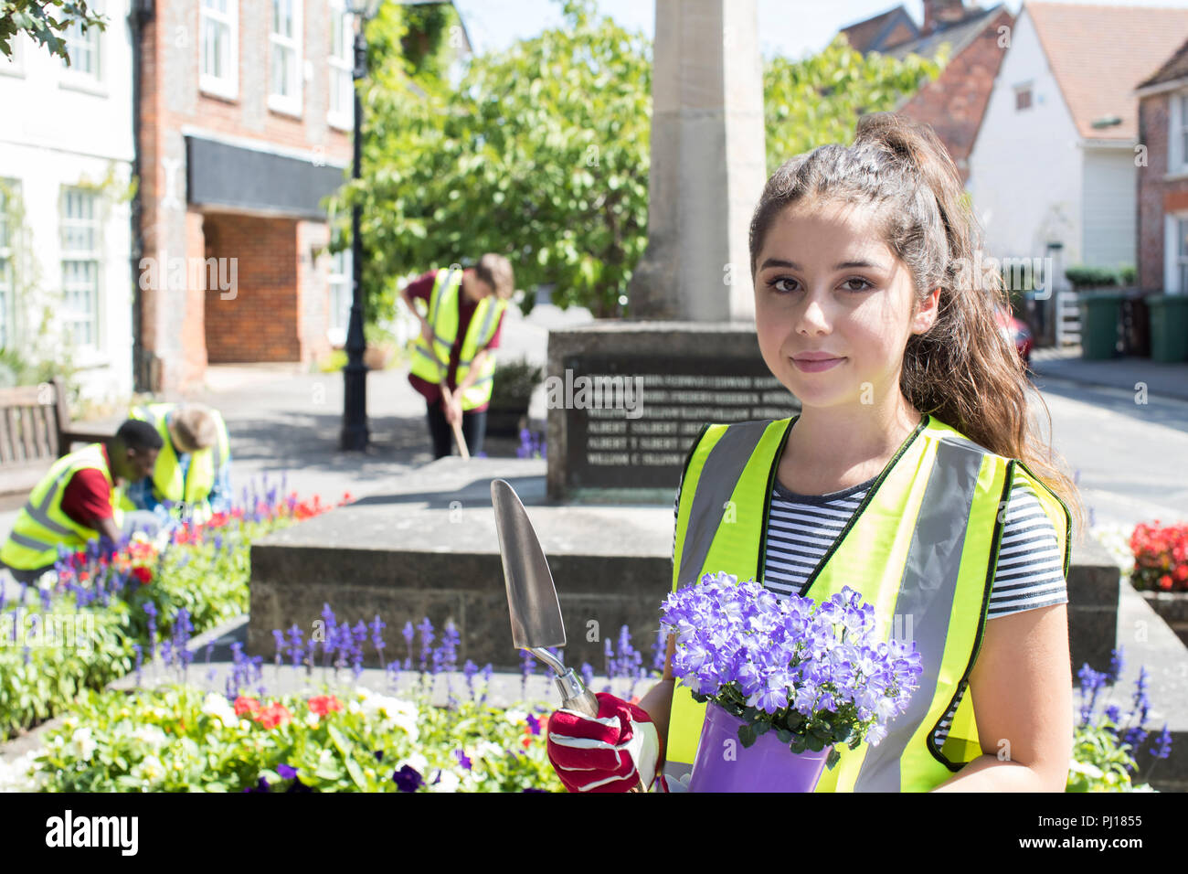 Gruppe von Hilfsbereit Jugendliche Pflanzen und Aufräumen öffentlichen Blumenbeete Stockfoto