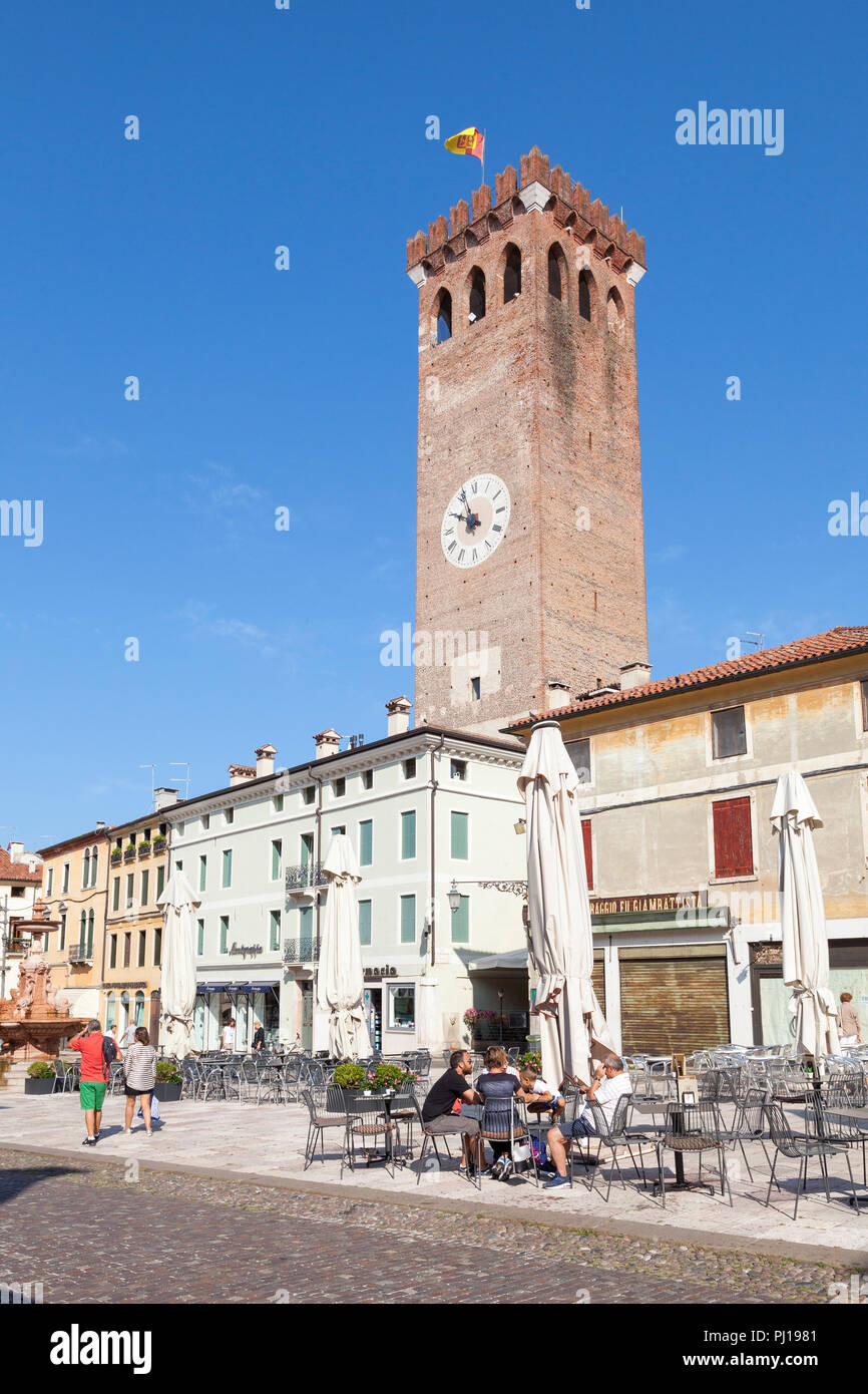 Mittelalterlichen Stadtturm, Piazza Garibaldi, Bassano del Grappa, Vicenza, Italien mit Leute an einem Tisch im Freien am frühen Morgen sitzt, bevor Wäs Stockfoto