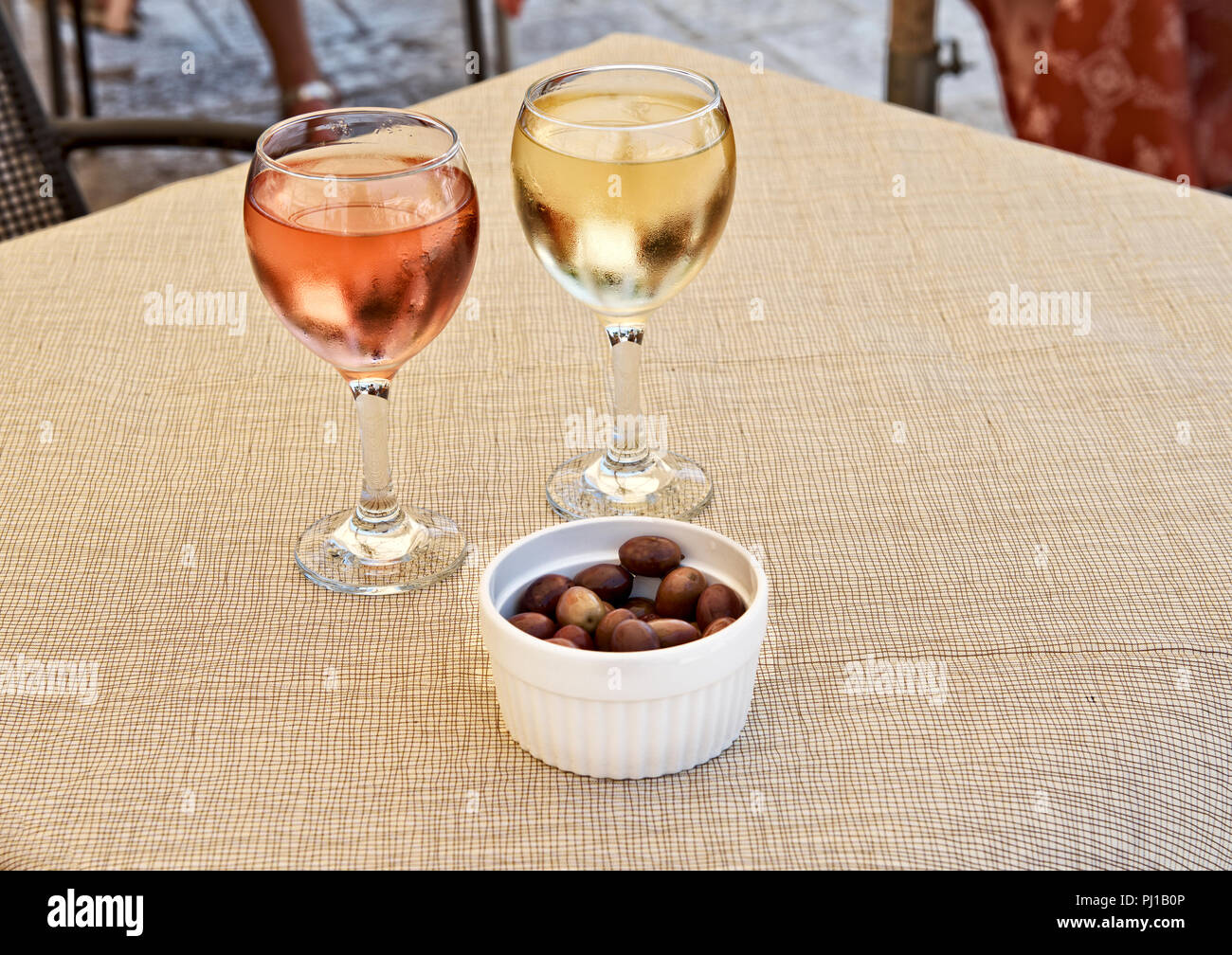 Gläser weiß und Rose Wein mit einem Teller Oliven Stockfoto