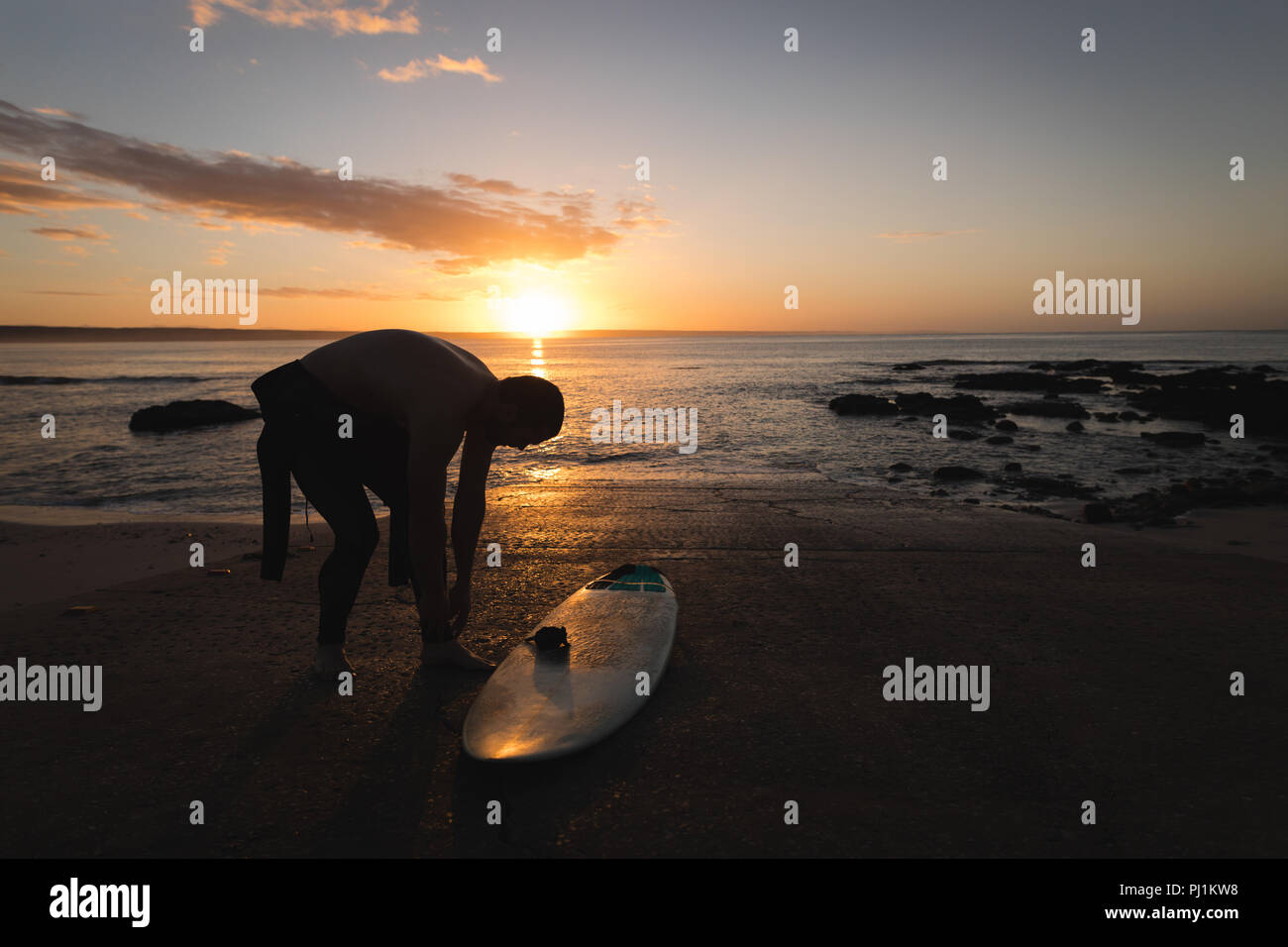 Surfer tragen Kostüm am Strand Stockfoto