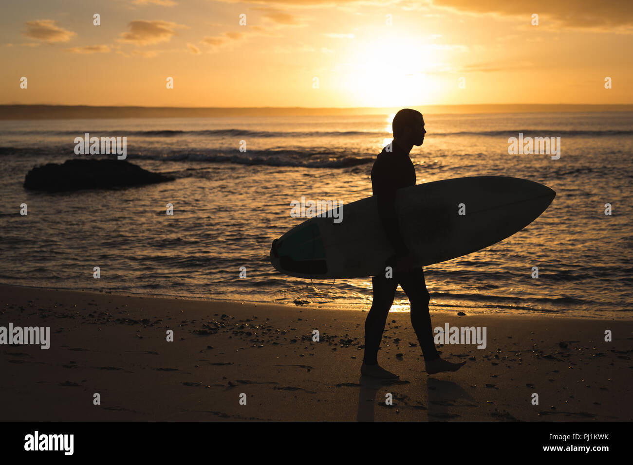 Surfer mit Surfbrett zu Fuß am Strand Stockfoto