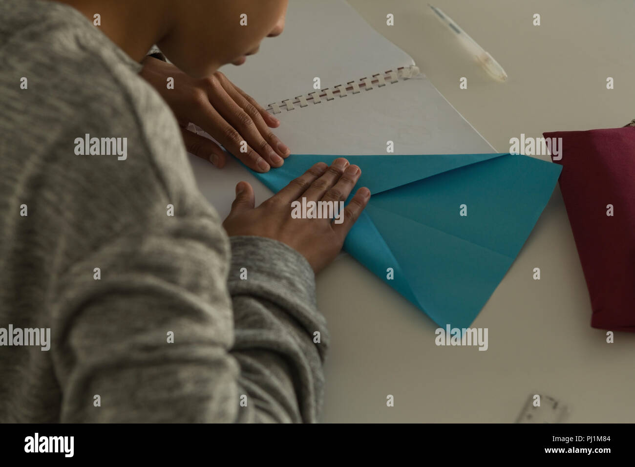 Kid, Paper Plane mit Handwerk Papier in der Ausbildung Institut Stockfoto