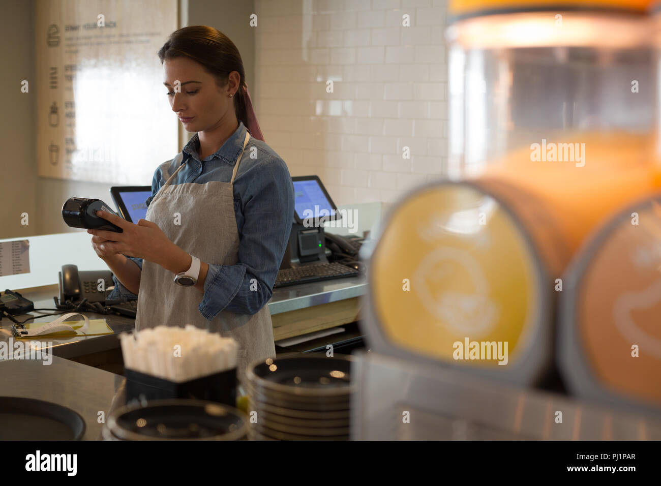Kellnerin mit NFC-Maschine Stockfoto