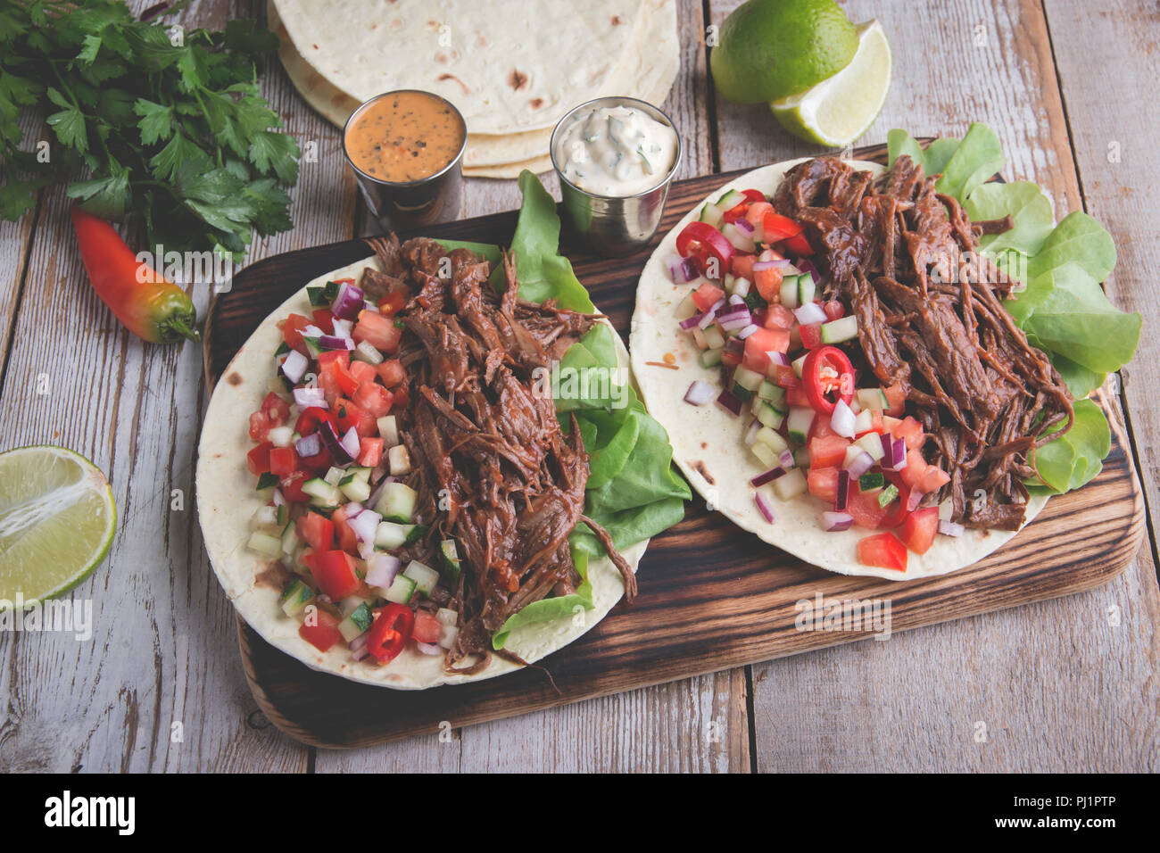 Mexikanische Tacos mit gebratenem Rindfleisch, Soße und salsa Tomaten Stockfoto