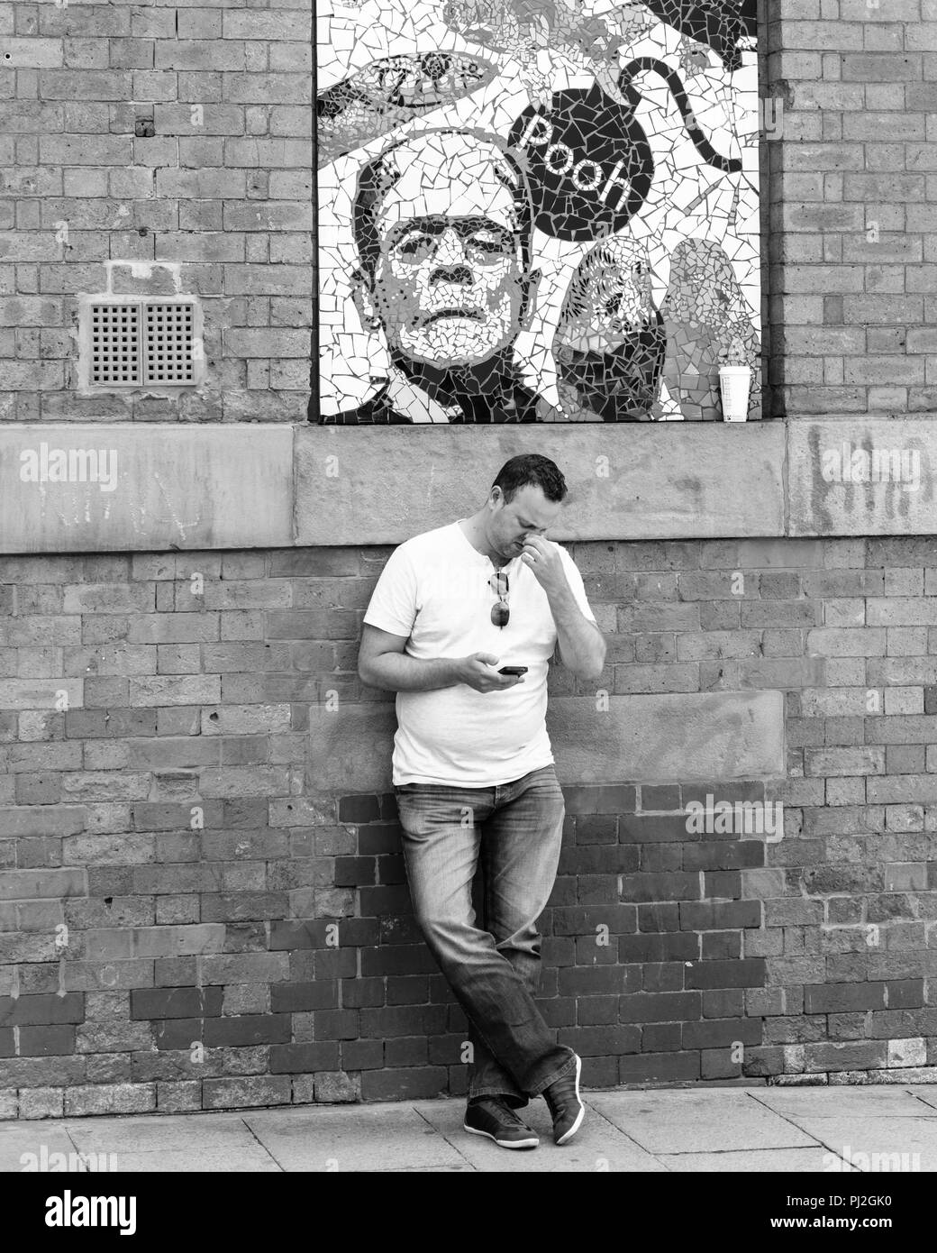 Amüsante Bild eines Mannes, der seine Nase Holding unter einem Plakat mit dem Wort pfui in Manchester Stockfoto