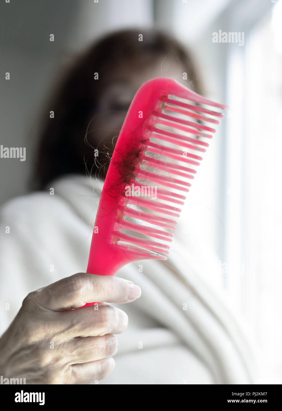 Der Kamm und voller Haare, dass diese Frau verliert Stockfoto