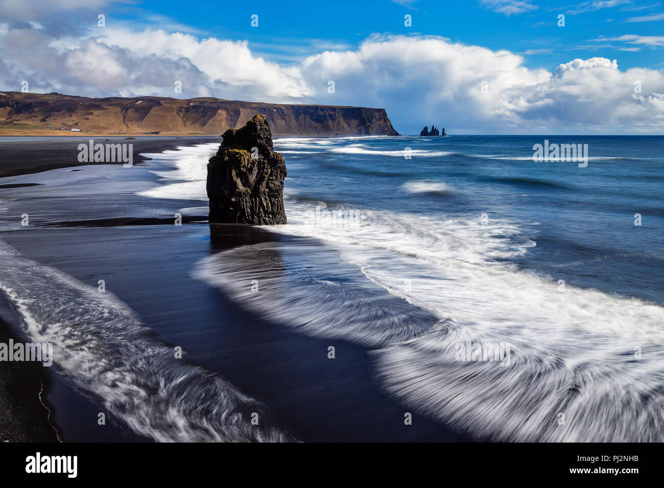 An der Südküste Islands dieser Lonely Rock Nadel ragt aus dem Meer und wird von den Wellen weggespült. Stockfoto