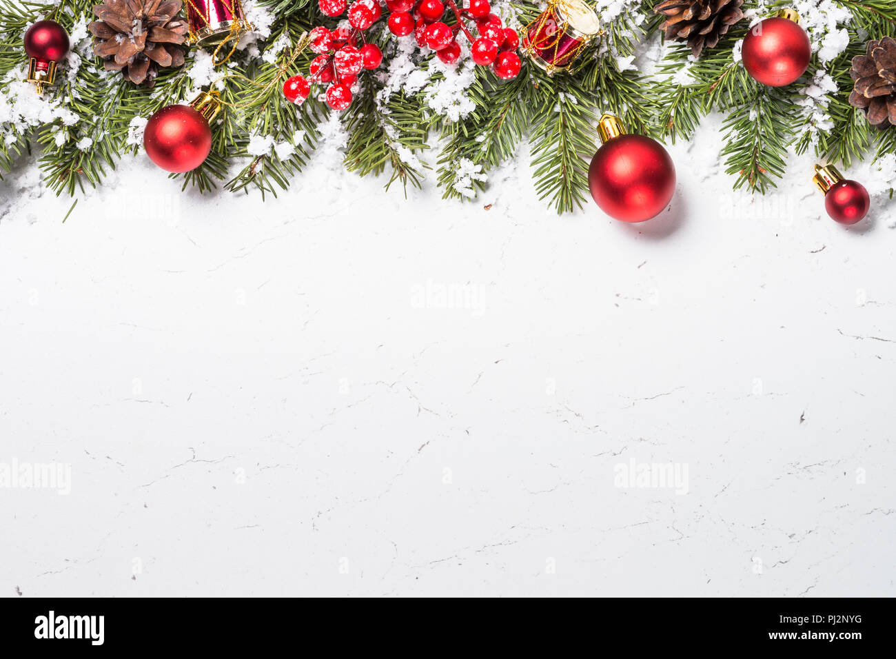 Weihnachten Hintergrund. Red Weihnachtsdekorationen mit Schnee und Fir Tree Branch auf weißem Marmortisch. Ansicht von oben mit der Kopie. Stockfoto