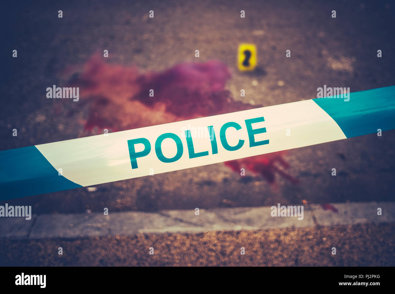 Ein Polizei Band neben dem Schauplatz eines gewaltsamen blutigen Verbrechen mit gelben Beweise Marker Stockfoto