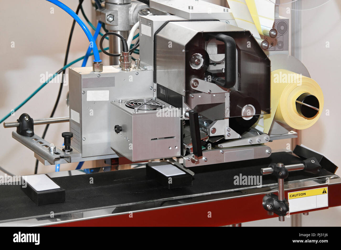 Label Printer und Applikator Maschine am Förderband Stockfoto