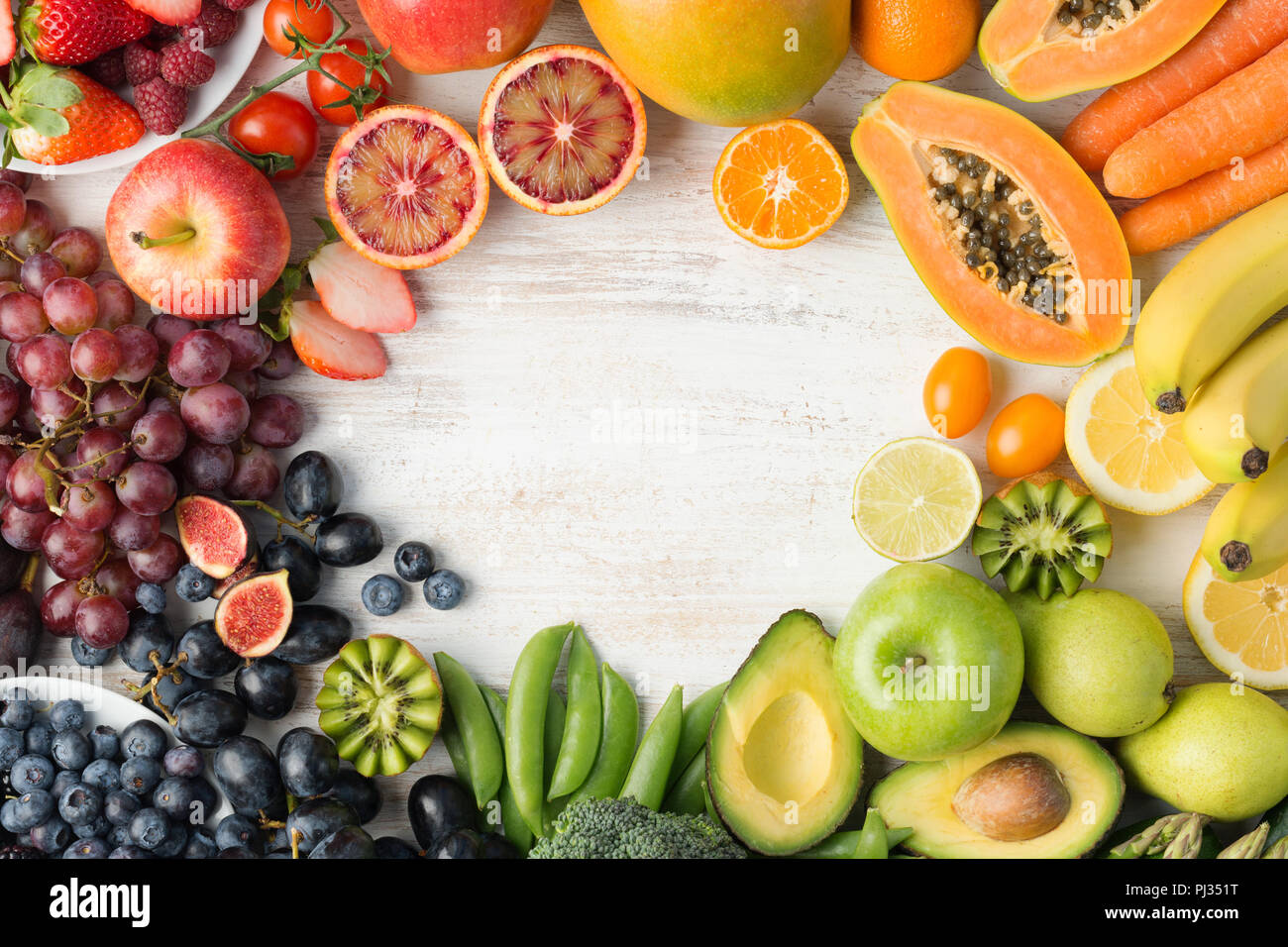 Das gesunde Essen, varieity von Obst und Gemüse in Regenbogenfarben an der aus weissen Tisch in einem Rahmen mit Kopie Raum angeordnet, senkrechte Draufsicht, selektiver Fokus Stockfoto